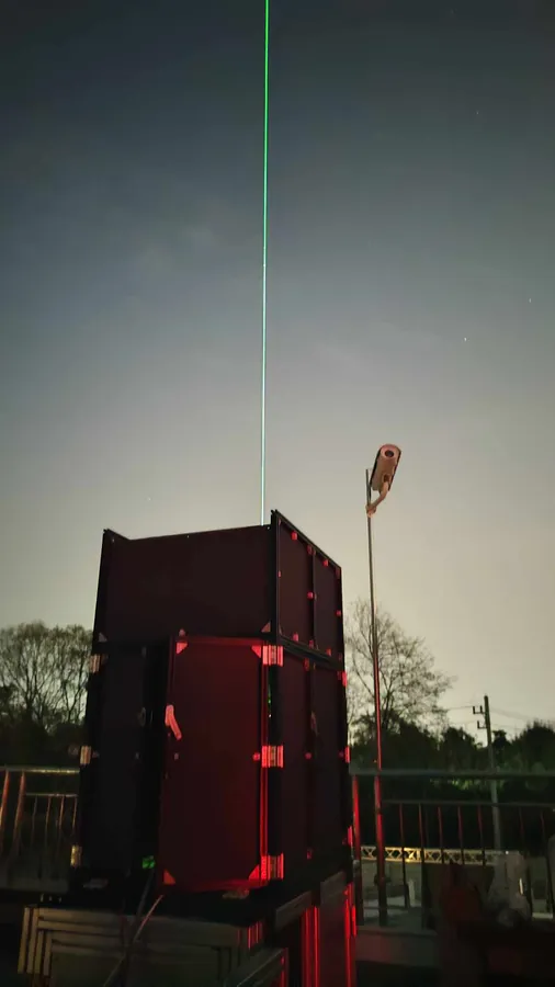 LiDAR station firing a green laser at night